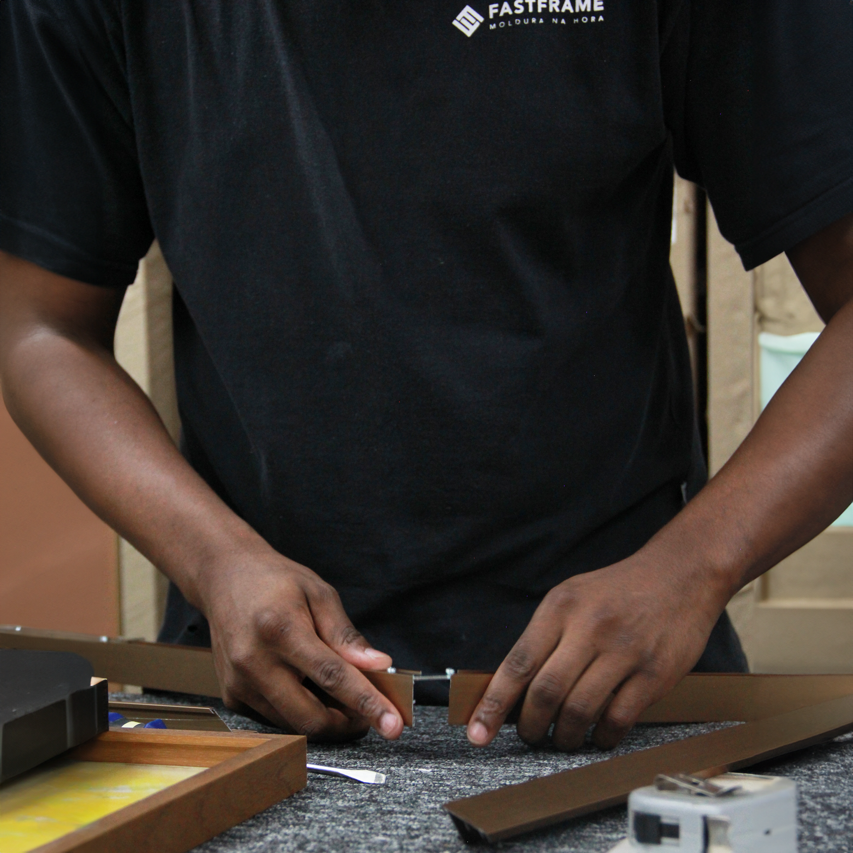 Fotografia de um moldureiro trabalhando na produção de uma arcada de moldura.