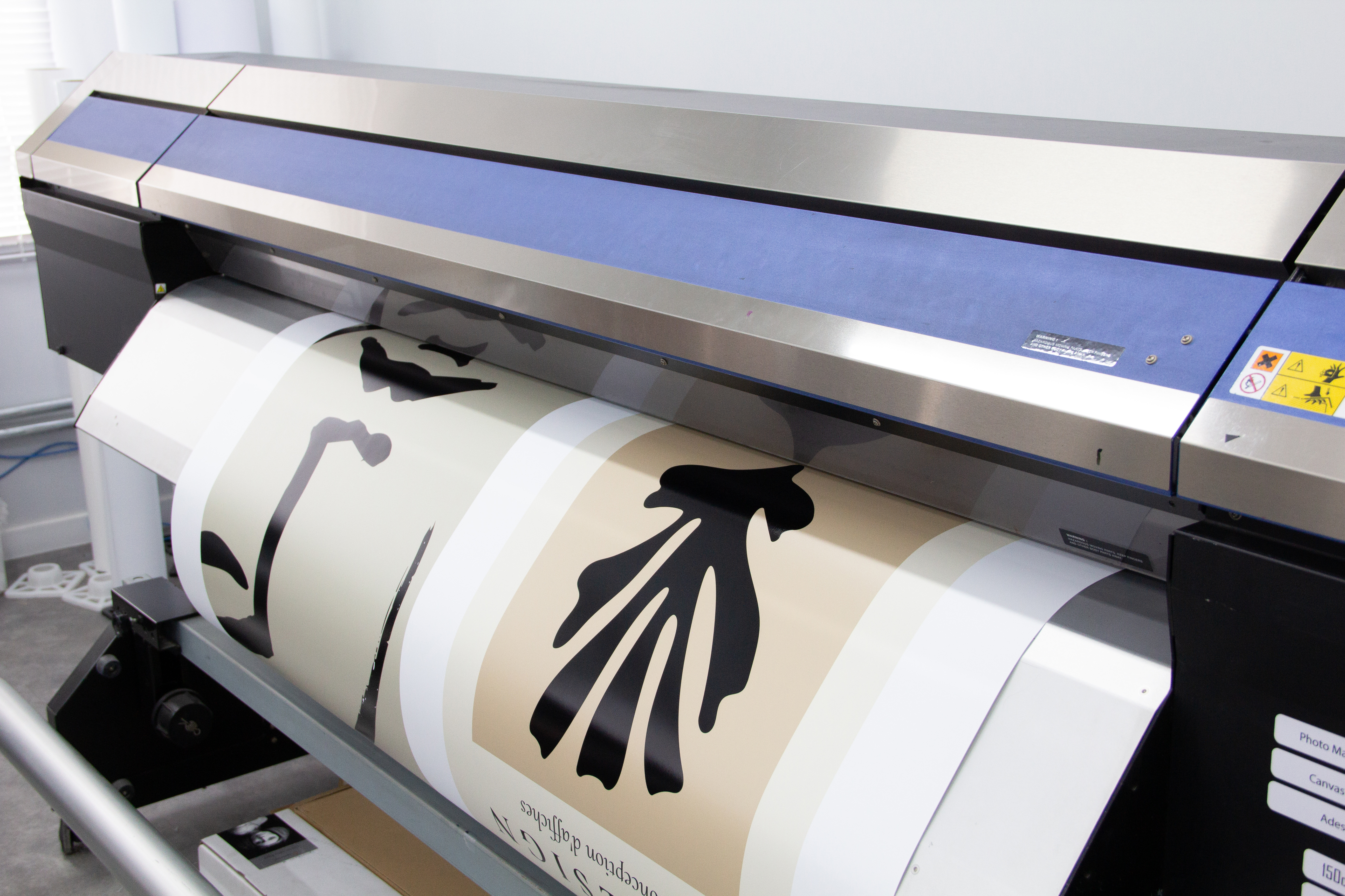 Fotografia da plotter imprimindo imagens no laboratório de impressão na sede da FastFrame em São Paulo.