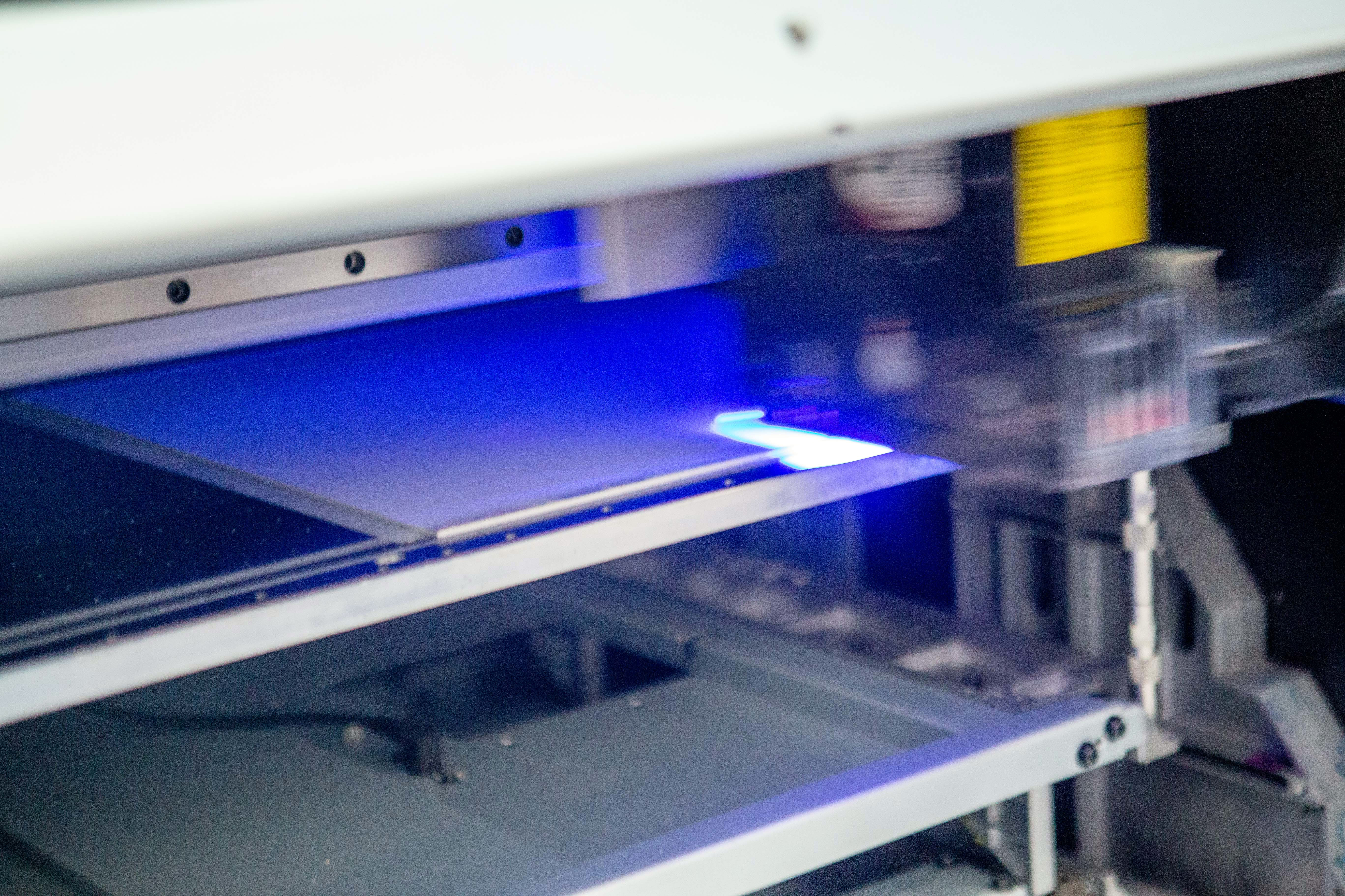 Fotografia da maquina de impressão UV trabalhando na sede da FastFrame em São Paulo.